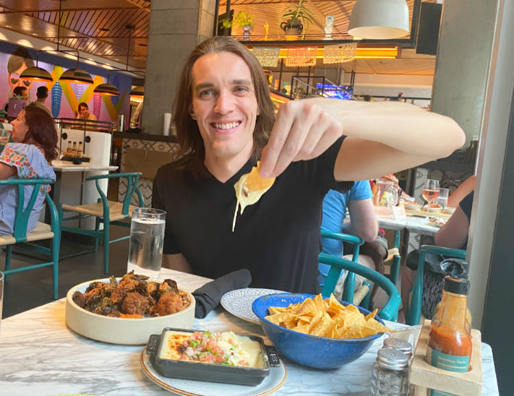 The author dipping a chip in queso at the Kachina Cantina restaurant in Denver Colorado