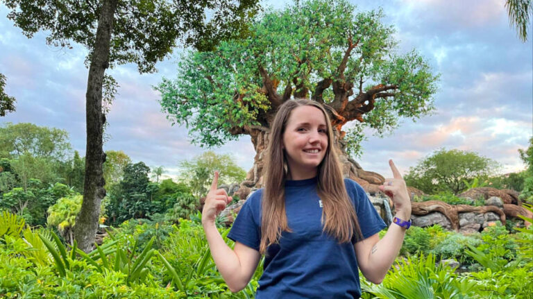 The author Katie posing for a photo in front of the Tree of Life at Animal Kingdom