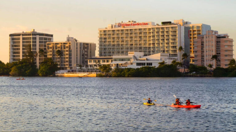 People kayaking on the lake with city skyline views in the background