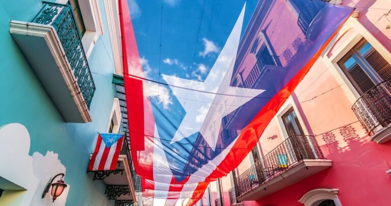 View of a large flag of Puerto Rico above the colorful street of San Juan