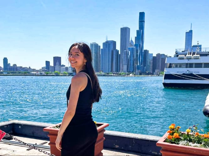 Travel Lemming Freelance Writer, Lea Rose, posing at the Navy Pier with the Chicago skyline in the background
