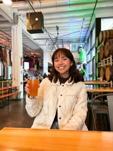 The author Lea Rose, holding a glass of Crab Rangoon at Dssolvr