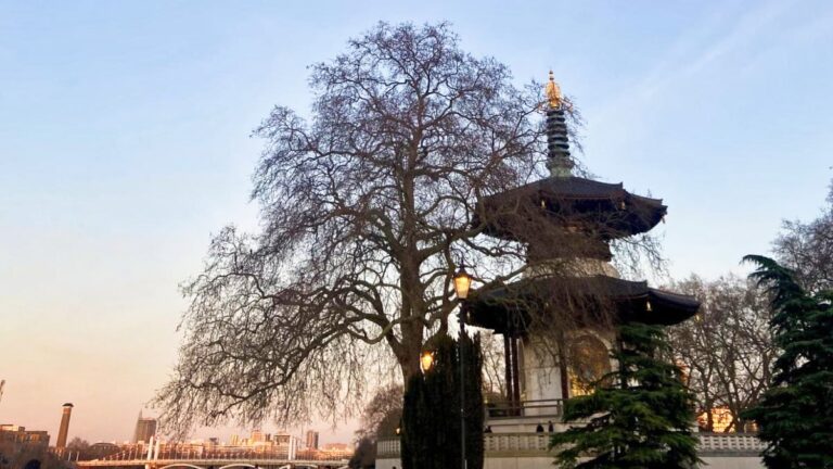 View of the gazebo and the city skyline from the park at sunset in London