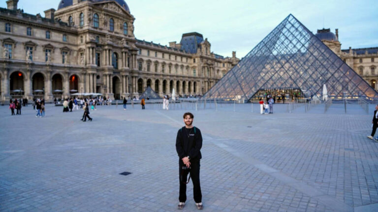 A man standing at the Louvre Museum