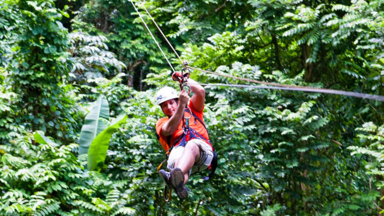 A man ziplining over the rainforest in Caguas