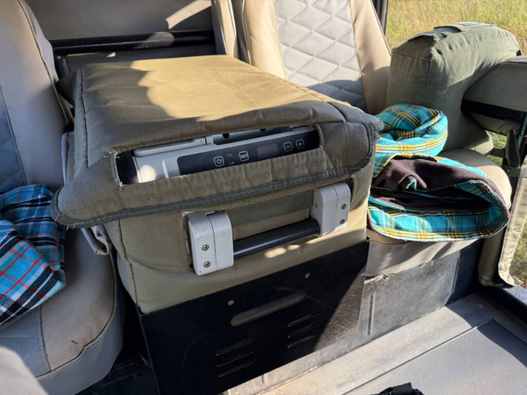 A mini-fridge between the seats in the safari vehicle