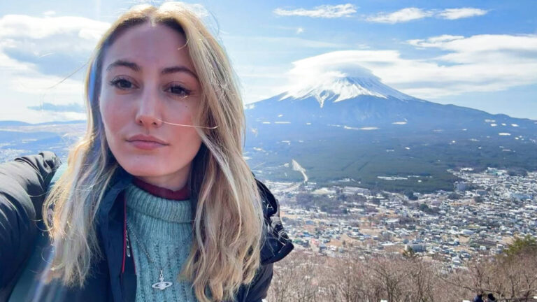 The author Sky Ariella posing for a photo with the Mount Fuji in the background