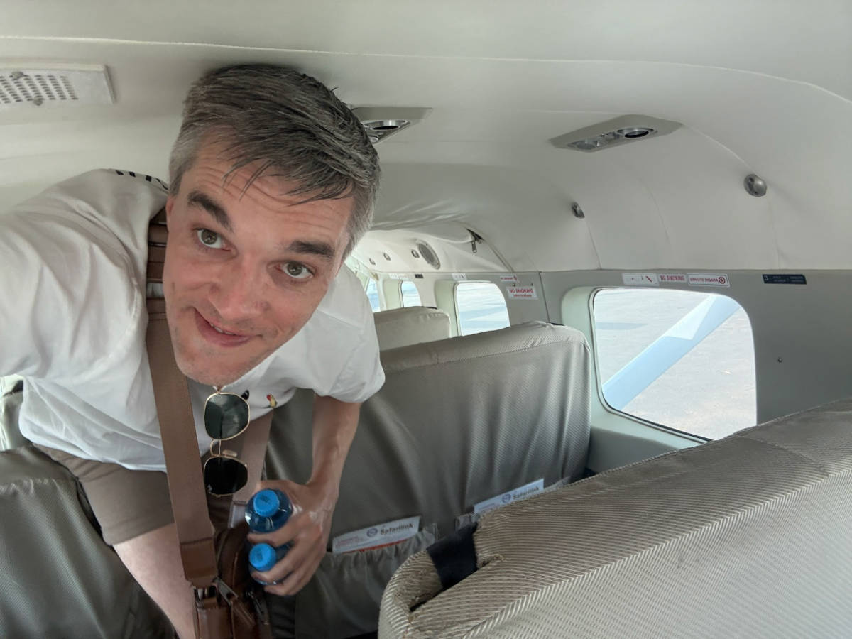 Travel Lemming founder, Nate Hake, ducking inside the small Cessna