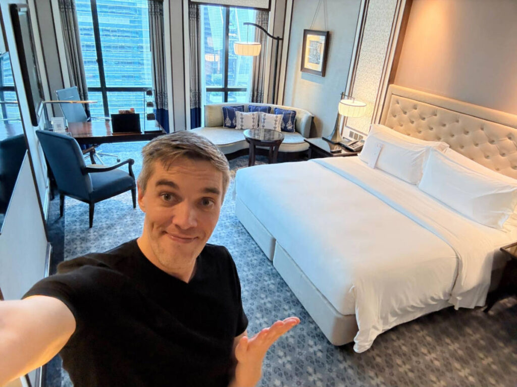 The author, Nate Hake smiling for a selfie inside his room at The Athenee Hotel