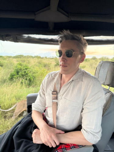 Travel Lemming founder Nate Hake, sitting on his chair while the lion pass the vehicle