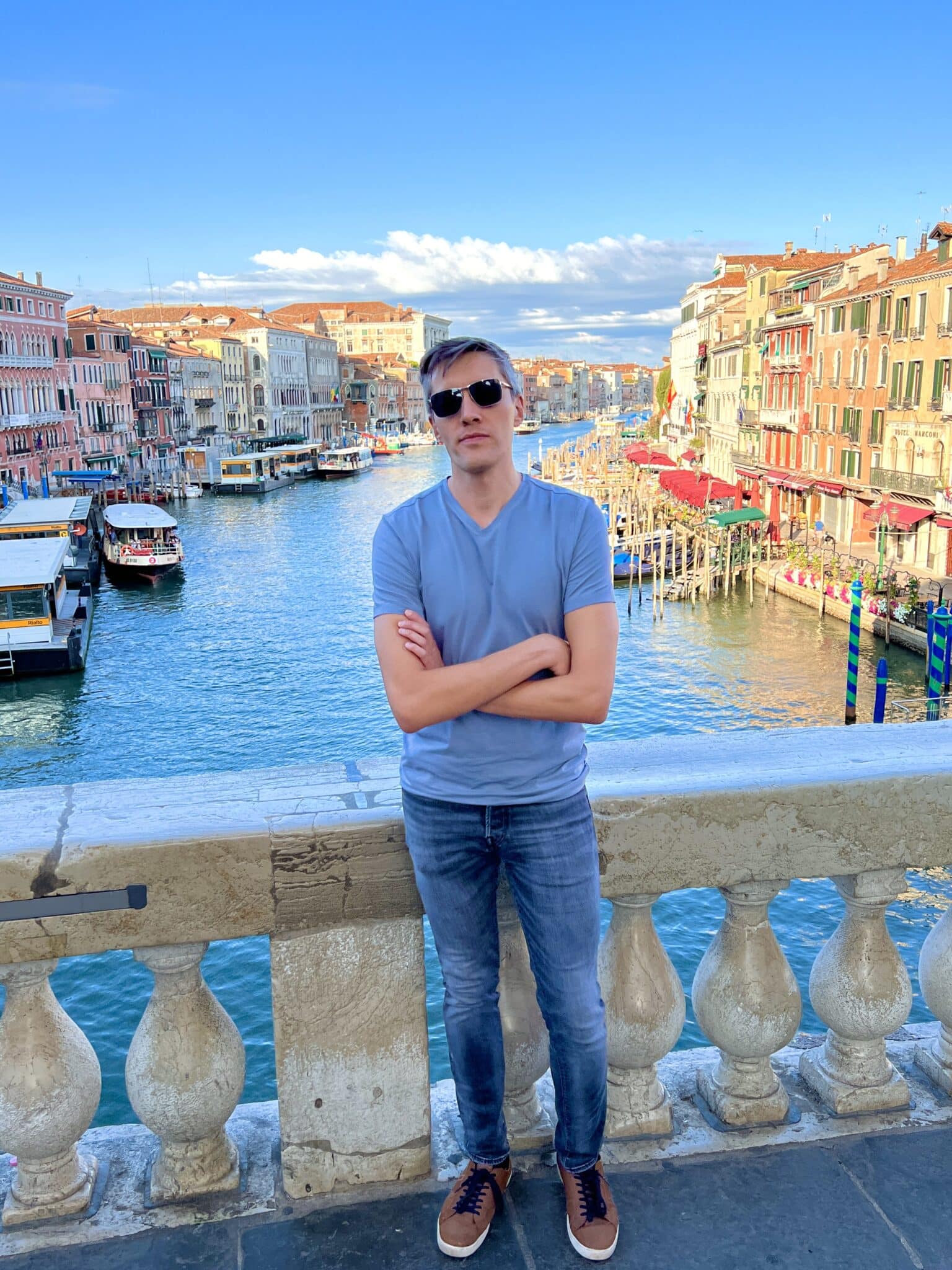 Nate Hake posing for a photo with the canal in Venice, Italy on his background