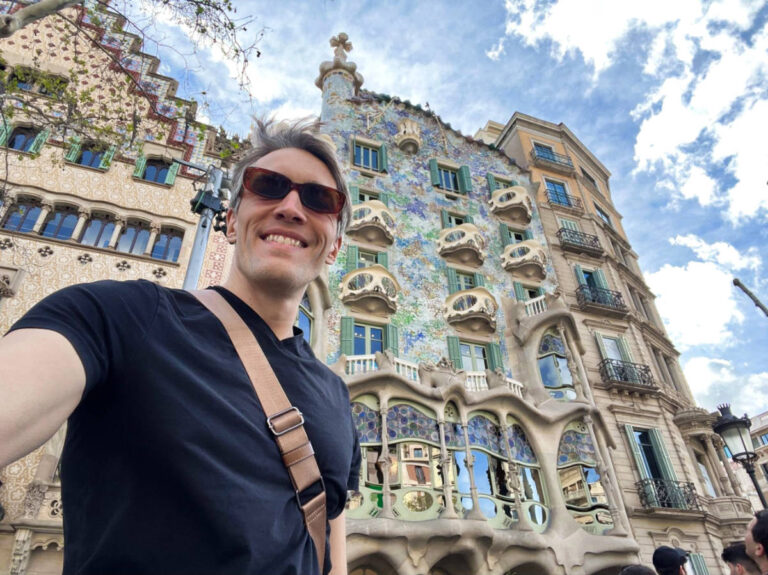 Travel Lemming Founder Nate Hake, smiling for a photo in front of Casa Batlló on a sunny day