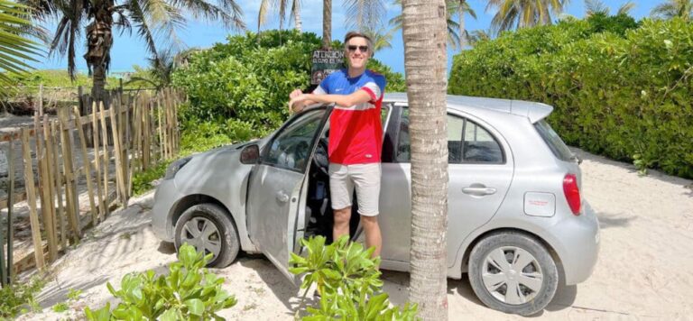 Nate beside a rented car on a beach in El Cuyo