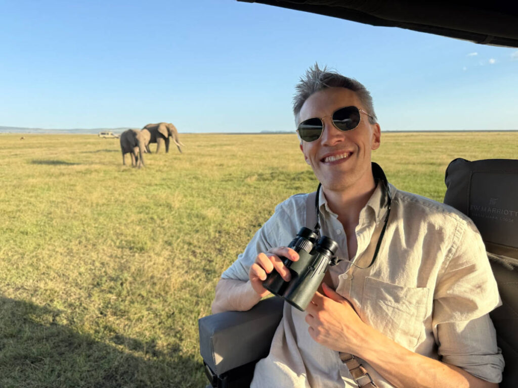 Travel Lemming founder Nate Hake, smiling for a photo with the elephants in the background