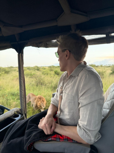 Travel Lemming founder Nate Hake, watching the lion passing by the vehicle