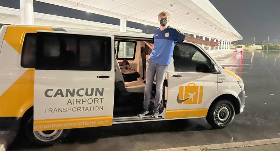 The author (Nate Hake) posing by the door of Cancun Airport Transportation service