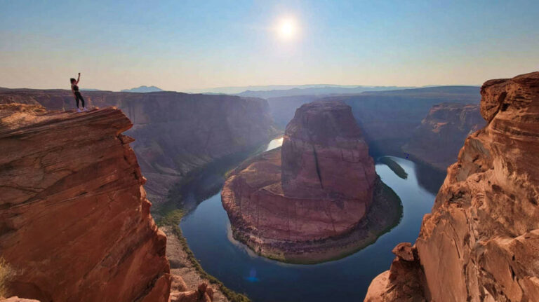 The author Niamh Hayes standing on the edge with an overlooking view of the Horseshoe Bend