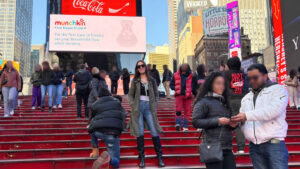 The author Niamh Hayes posing for a photo with the NYC signages in the background