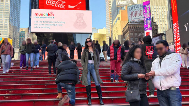 The author Niamh Hayes posing for a photo with the NYC signages in the background