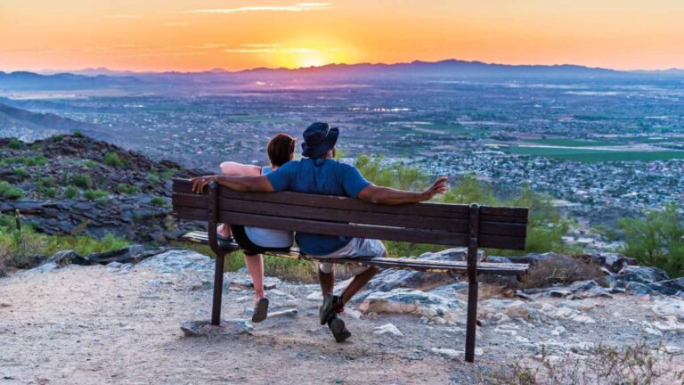 A couple sitting and watching the overlooking view of Phoenix during sunset