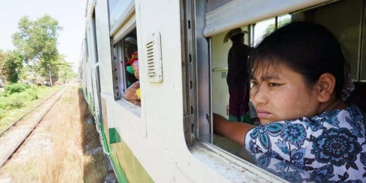 A woman gazes thoughtfully out the train window