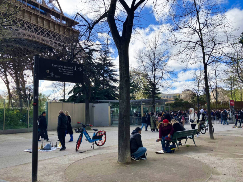 Crowd sitting outside the  Eiffel Tower