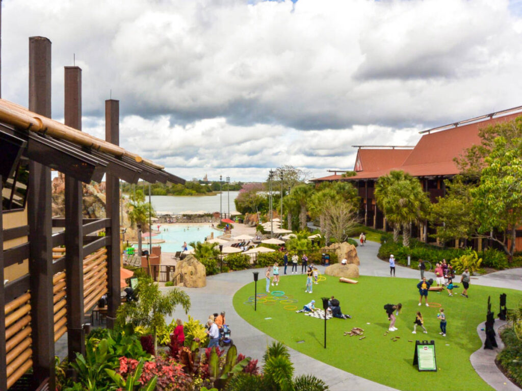 View of the people enjoying the lawn area at the Polynesian Village Resort in Disney 