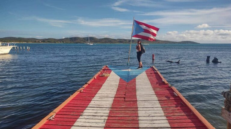 The author, Vanessa Ramos with the Puerto Rico flag in the beach