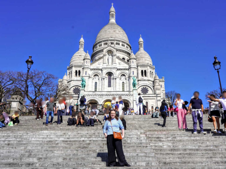 The author Rachel Kapelke-Dale posing for a photo on the steps of Sacré Coeur Basilica