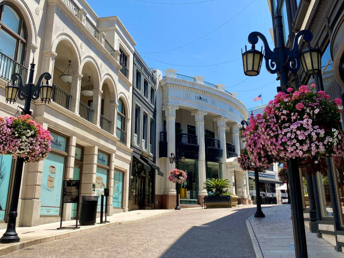 Street lined with shops and colorful flowers at Rodeo Drive