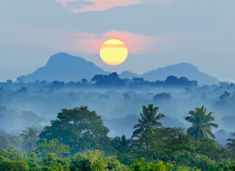 View of the sun setting in the middle of the mountains