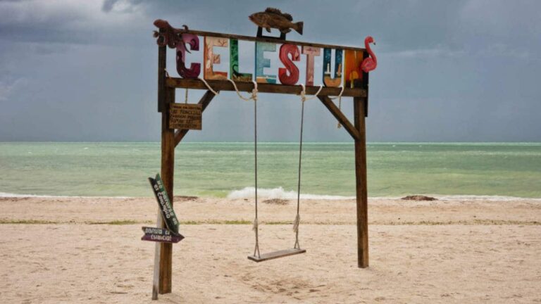 View of a swing on a beach with Celestun text on top