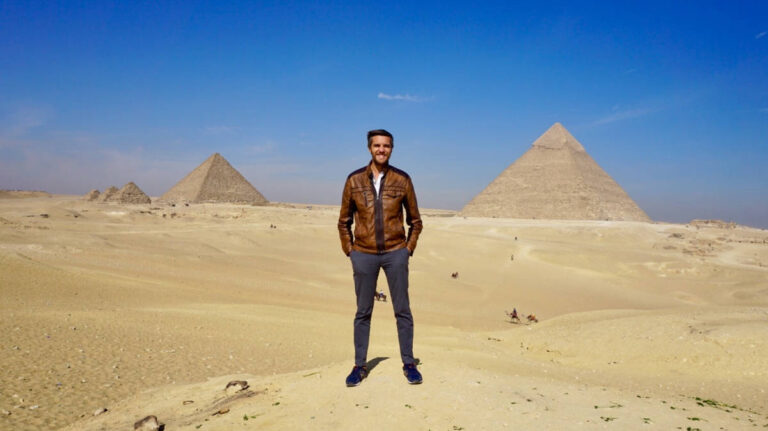 The author, Nate Hake smiling for a photo with the pyramids of Giza on his background
