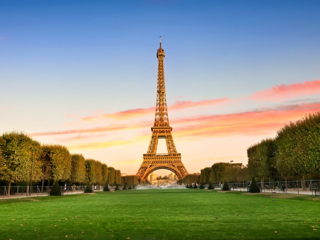 View of the picturesque Eiffel Tower in the middle of greenery at sunset