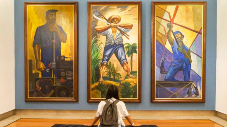 Author Vanessa Ramos sitting and appreciating the paintings at The Puerto Rico Art Museum