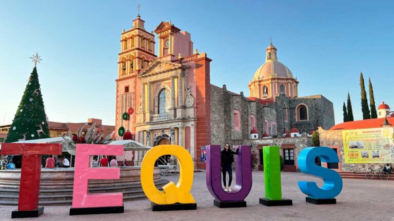 Writer Clara taking a photo with the Tequis sign