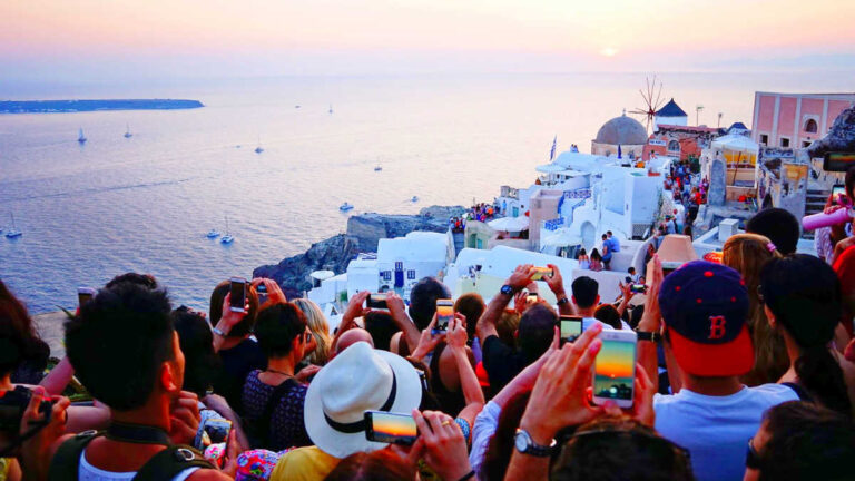 View of the tourist crowd taking a photo of the sunset in Santorini