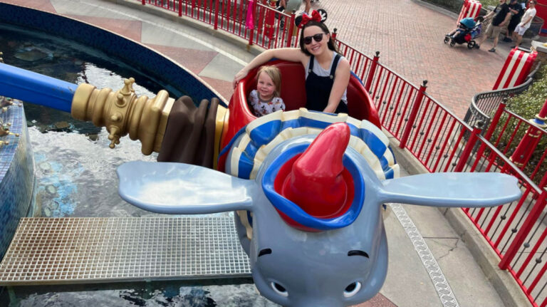 Travel Lemming author Katie and her son riding the Dumbo the flying elephant
