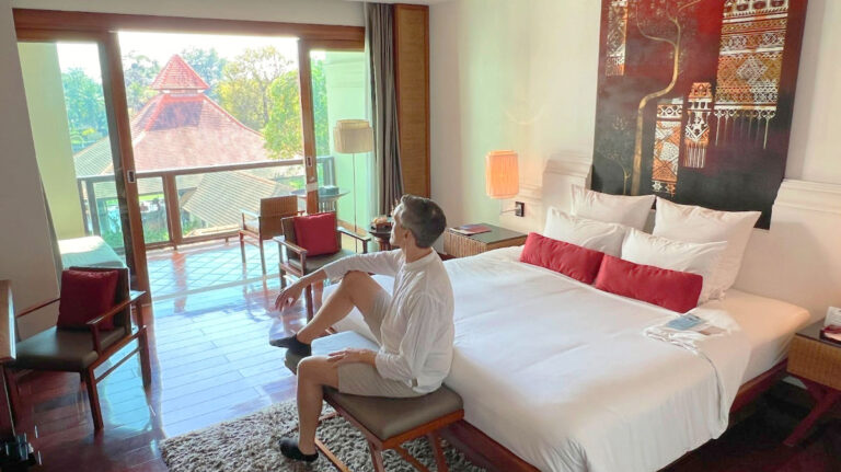 Travel Lemming founder sitting on a chair and looking at the view outside the RatiLanna Riverside