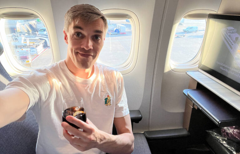 Nate Hake, the founder and CEO of Travel Lemming smiling for a selfie while on a plane