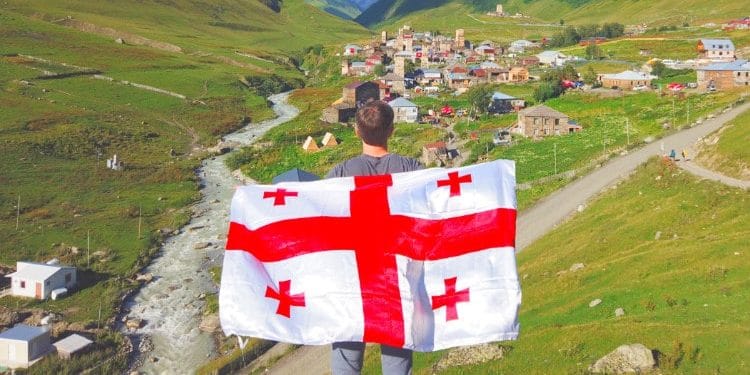 Travel Lemming Founder Nate Hake holding the Georgian Flag on his back