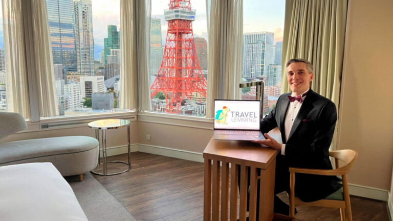 Travel Lemming Founder Nate showing his laptop in a room with a view of the Tokyo tower the Prince Park Tower Tokyo Hotel