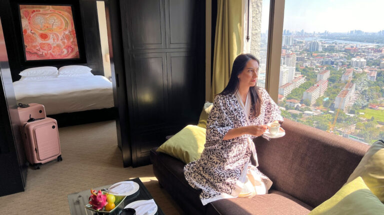 Travel Lemming writer Clara sitting on the sofa while holding a cup of coffee at the Banyan Tree Bangkok