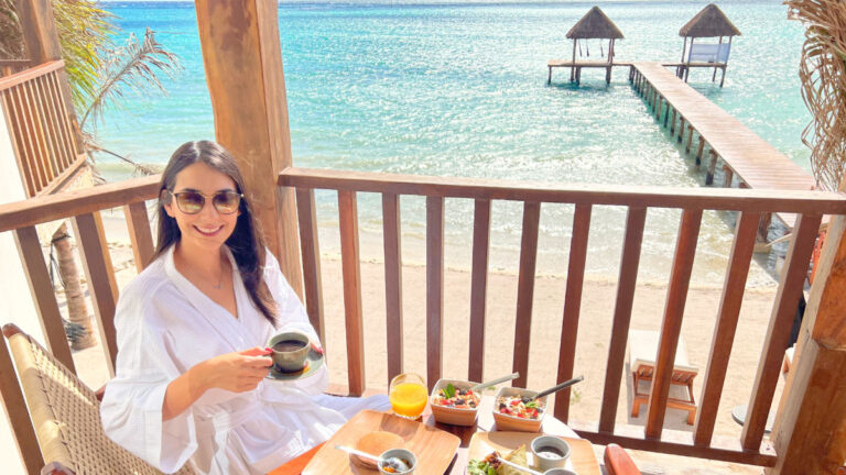 Travel Lemming writer Clara enjoying breakfast overlooking the beach on a private hotel balcony in Tulum