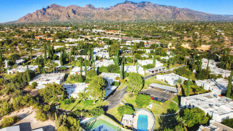 Aerial view of Tucson, showcasing the vast landscape and surrounding mountains under a clear blue sky