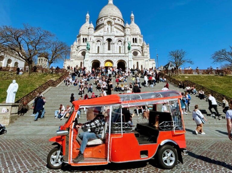 Red tuk-tuk below the crowded steps leading up to the Basilica of the Sacré-Cœur