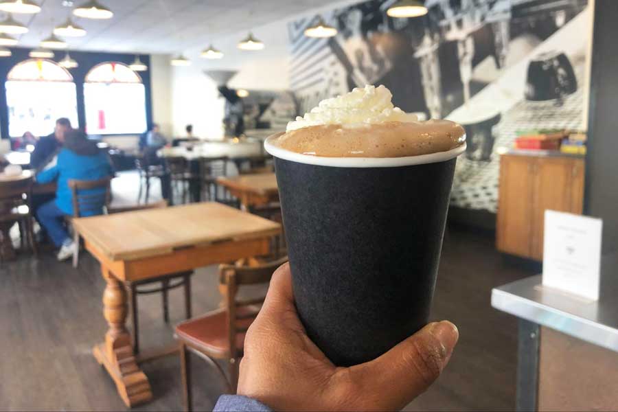 A hand holding a cup of coffee