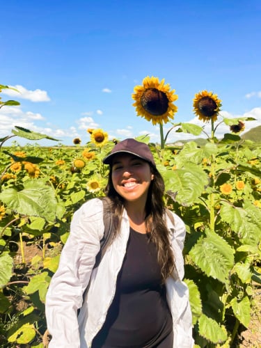 The author Vanessa Ramos, posing for a photo in front of the sunflower field in Guanica