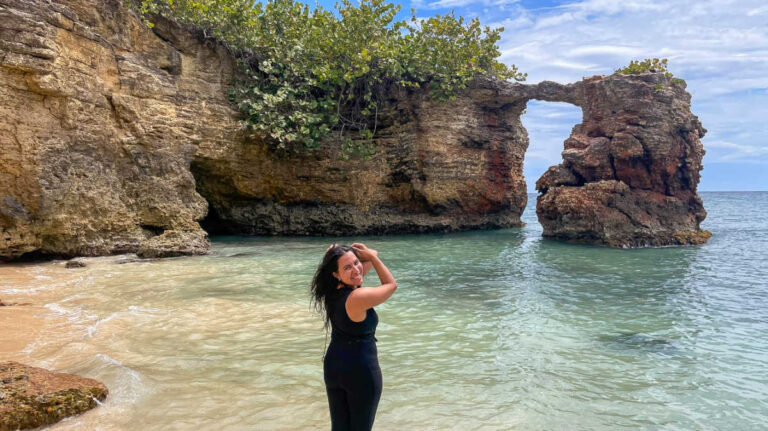 The author Vanessa Ramos enjoying at the beach with the view of the rock formations