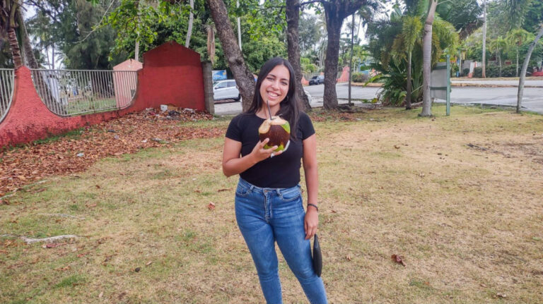 The author Vanessa Ramos holding a coconut fruit